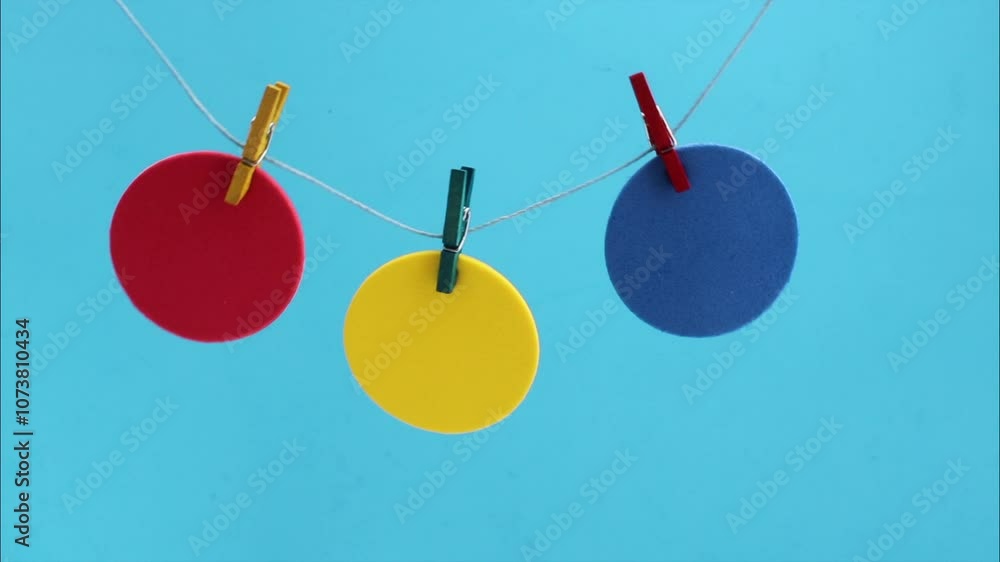 Different colored circles hung with clothespins swing Different colored circles hung with clothespins swing