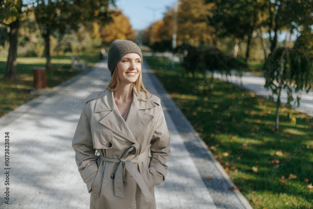 Stylish woman in trench coat with golden leaves background Stylish woman in trench coat with golden leaves background