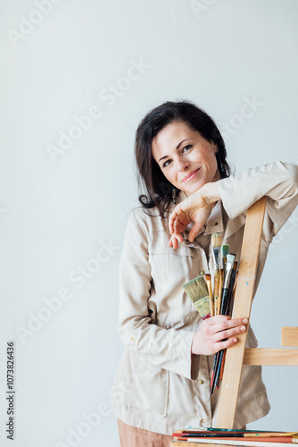 Female artist holding paint brushes in her hands photo