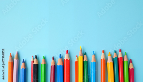 Colorful arrangement of pencils on a light blue background, symbolizing creativity and artistic expression
