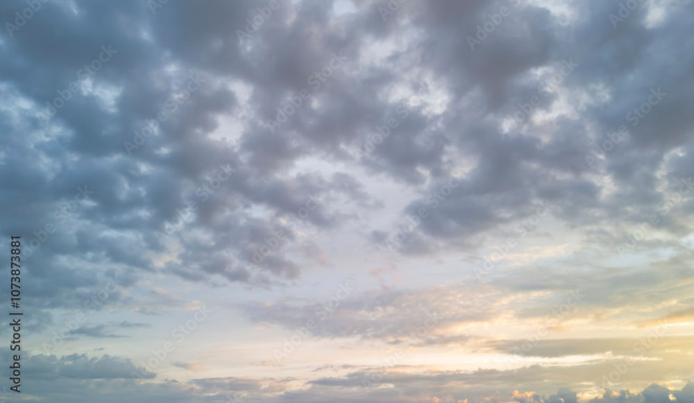 Fototapeta premium Beautiful cloudy sky at sunset with soft pastel colors illuminating the horizon
