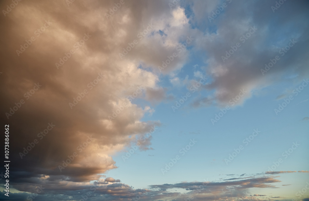 Obraz premium Blue-pink clouds in the evening sky, cumulus clouds illuminated by the setting sun, dense cloud cover in the sky.