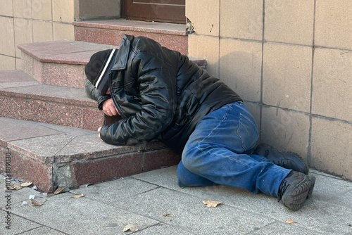 Homeless dirty person lying on the ground in Moscow, Russia photo