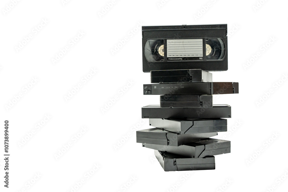 A stack of old VHS tapes on top of each other. The stack is made up of different sizes of tapes, and the top one is the largest. Concept of nostalgia and the idea of preserving memories A stack of old VHS tapes on top of each other. The stack is made up of different sizes of tapes, and the top one is the largest. Concept of nostalgia and the idea of preserving memories