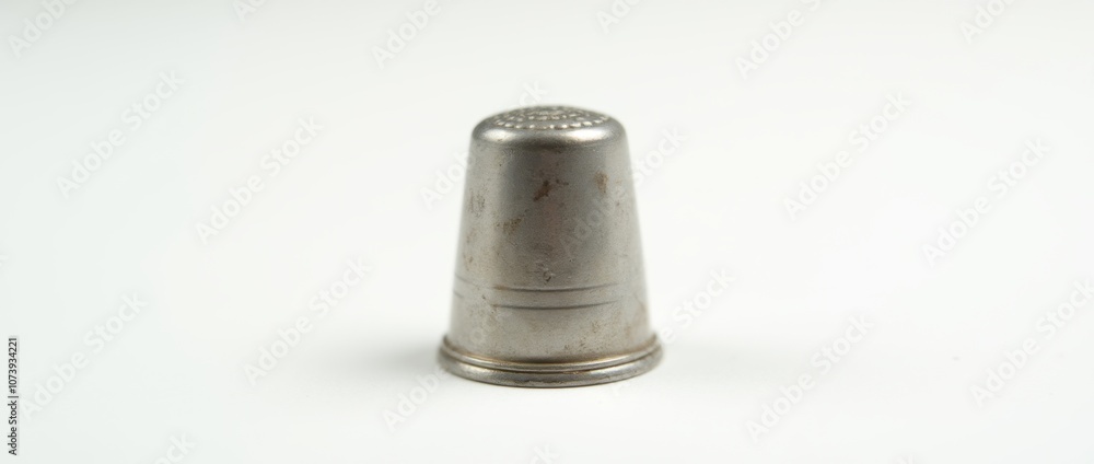 Small Metallic Sewing Thimble with Subtle Wear and Tear on White Background Small Metallic Sewing Thimble with Subtle Wear and Tear on White Background