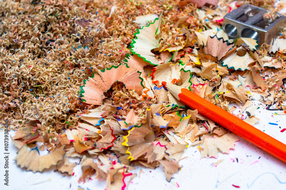 Colorful pencil shavings and sharpened tools scattered across a workspace filled with creative remnants in bright daylight Colorful pencil shavings and sharpened tools scattered across a workspace filled with creative remnants in bright daylight