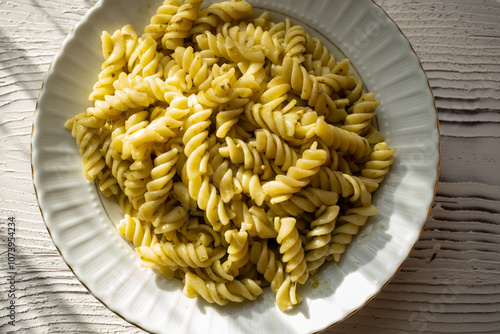 pasta with pesto sauce on brown background in close-up