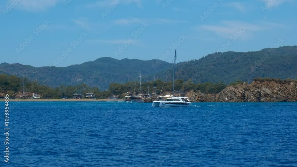 Sailing yacht floating on ribbed river. A cute summer trip on big speed yacht against tropical mountains in the day light. Sailing yacht floating on ribbed river. A cute summer trip on big speed yacht against tropical mountains in the day light.