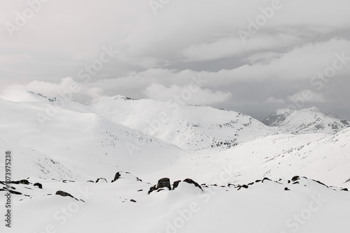 Fototapeta Naklejka Na Ścianę i Meble -  Beautiful snow-covered mountain massif against the background of the sky, on which white clouds float