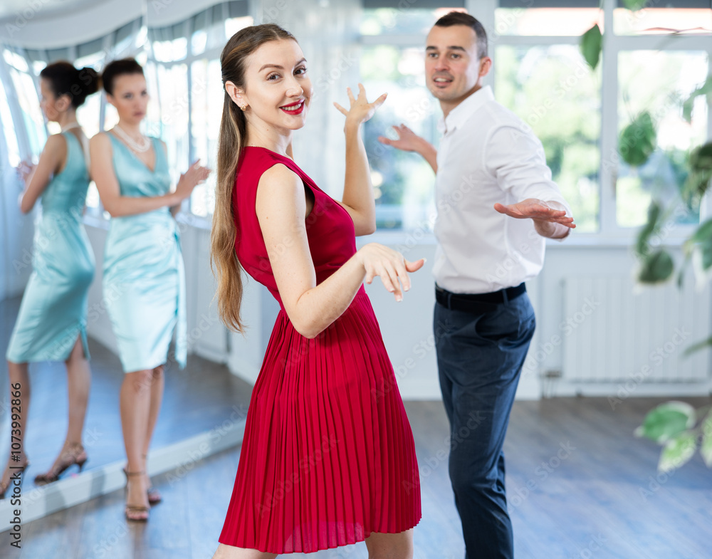 Naklejka premium Guy and girl in stage costumes, under guidance of mentor, practice boogie woogie in choreographic studio. Ballet dancers during personal training session. Professional rendering of dance entertainment