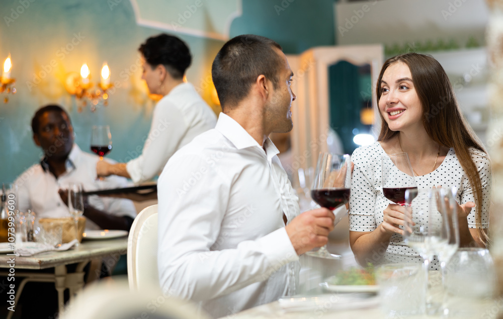 Young couple having romantic dinner and drinking red wine at restaurant Young couple having romantic dinner and drinking red wine at restaurant