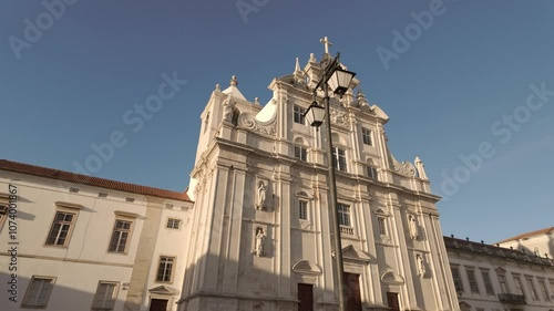 The New Cathedral of Coimbra, Portugal, stands tall and majestic against a clear blue sky.