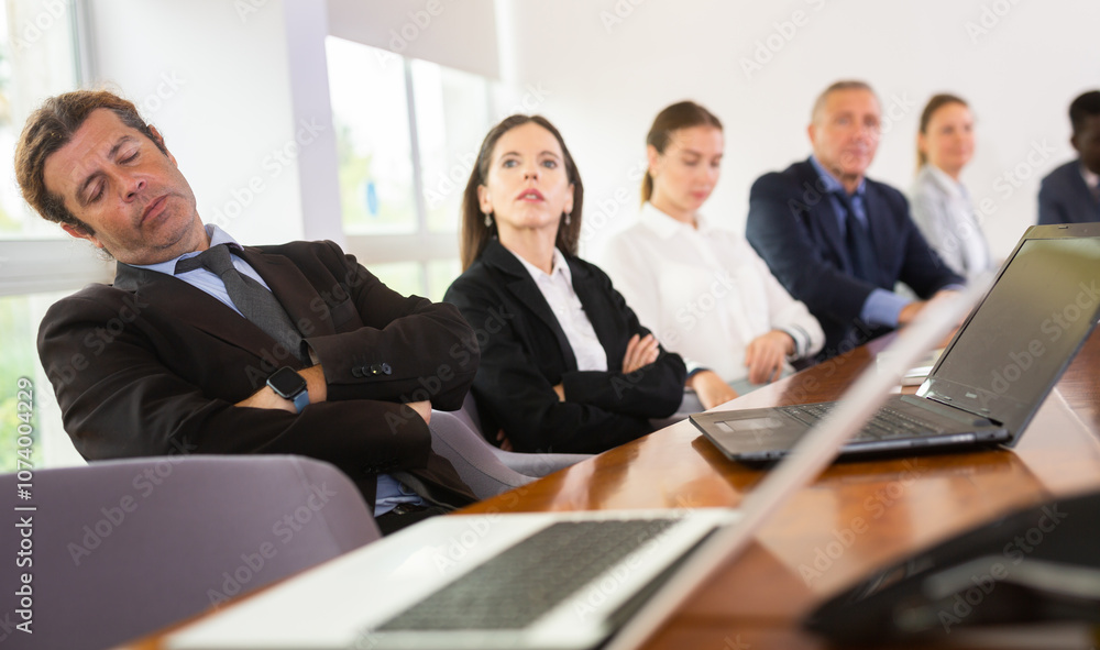 Tired businessman fell asleep at a business meeting in the negotiation room Tired businessman fell asleep at a business meeting in the negotiation room