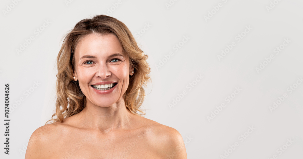 Natural Beauty. Portrait Of Attractive Smiling Middle Aged Woman With Naked Shoulders Posing Over Light Grey Studio Background, Happy Nude Beautiful Female Looking At Camera, Panorama With Copy Space Natural Beauty. Portrait Of Attractive Smiling Middle Aged Woman With Naked Shoulders Posing Over Light Grey Studio Background, Happy Nude Beautiful Female Looking At Camera, Panorama With Copy Space