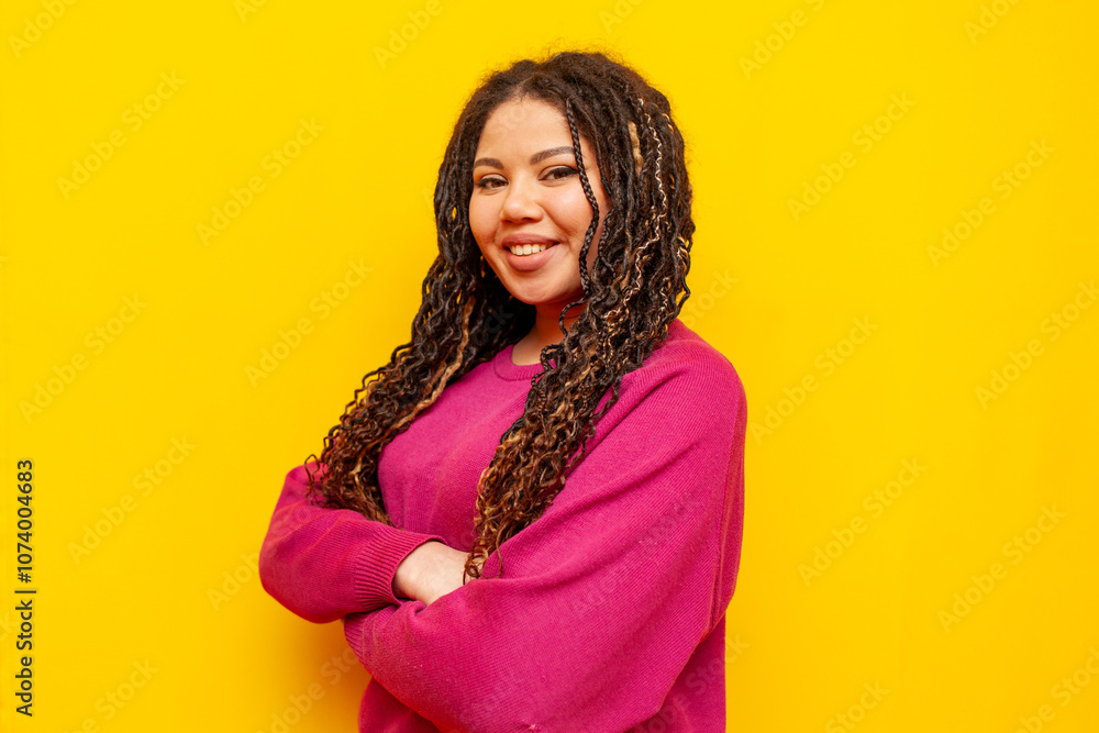 plump african american woman with dreadlocks smiling with arms crossed on yellow background, big plus size girl with pigtails looking at camera plump african american woman with dreadlocks smiling with arms crossed on yellow background, big plus size girl with pigtails looking at camera