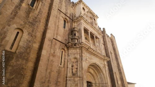 The University of Coimbra, Portugal, stands tall and majestic against a clear blue sky.