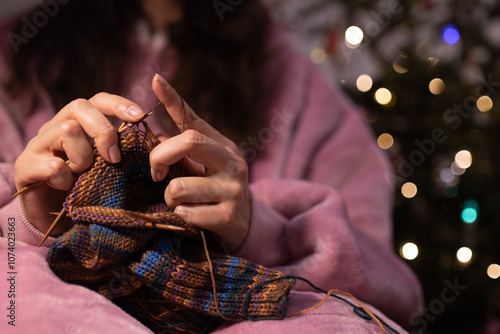 Schilderij op canvas a woman knitting needles by the Christmas tree
