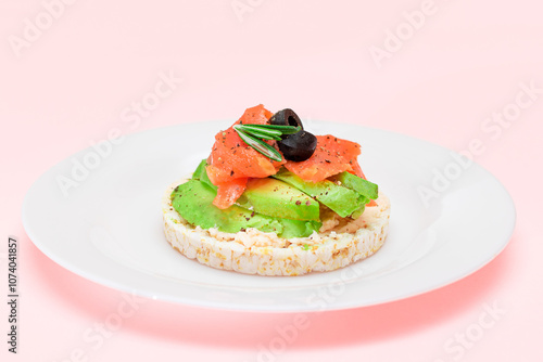 Rice Cake Sandwich with Fresh Salmon, Avocado and Olives on White Plate. Easy Breakfast. Diet Food. Quick and Healthy Sandwiches. Crispbread with Tasty Filling. Healthy Dietary Snack