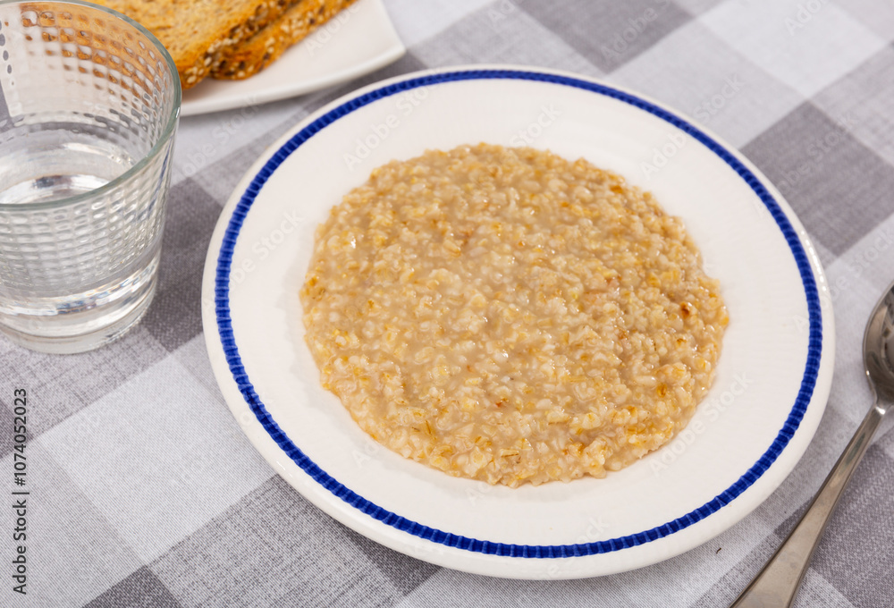 Appetizing milk oatmeal porridge served on plate for breakfast Appetizing milk oatmeal porridge served on plate for breakfast