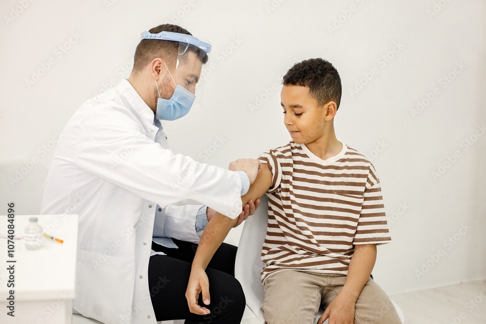 Obraz premium Male doctor doing a vaccination to a multiracional boy