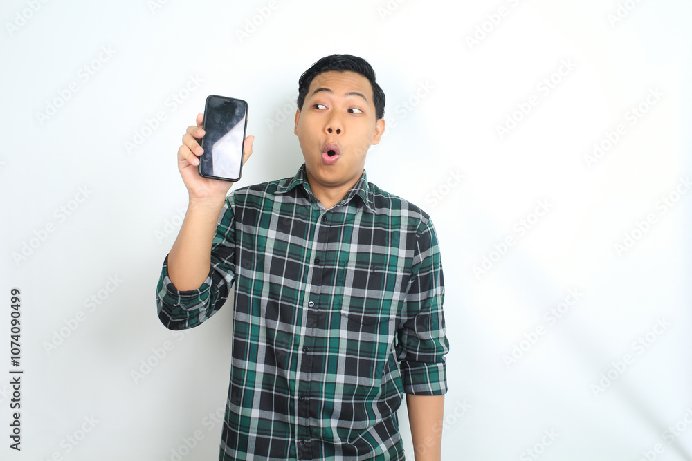 attractive asian man show smartphone screen with surprised face expression isolated on white background attractive asian man show smartphone screen with surprised face expression isolated on white background