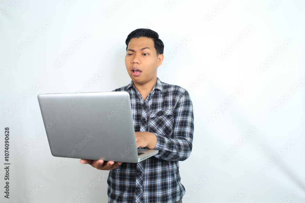 thoughtful asian man holding laptop looks confused and curious isolated on white background, male wearing plaid shirt using computer thoughtful asian man holding laptop looks confused and curious isolated on white background, male wearing plaid shirt using computer