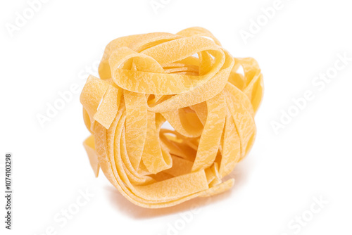 One Classic Italian Raw Egg Fettuccine - Isolated on White Background. Dry Twisted Uncooked Pasta. Italian Culture and Cuisine. Raw Golden Macaroni Pattern - Isolation