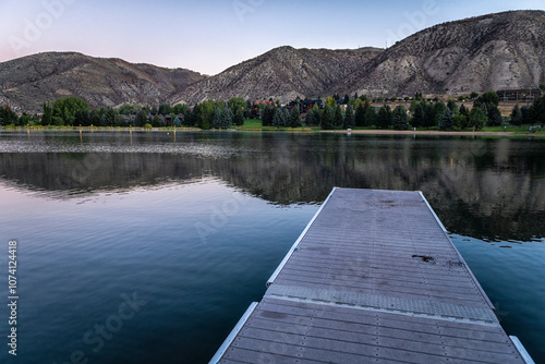 Nottingham lake park dock in Avon, Colorado with fishing pier wharf boardwalk at sunrise in small mountain village ski town city in fall autumn photo