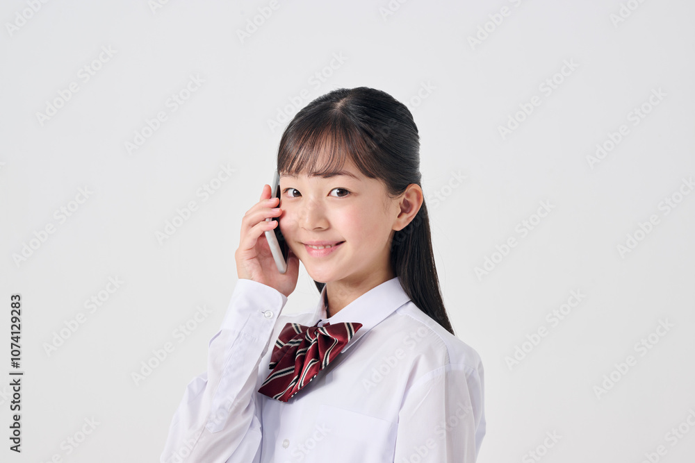 白背景,電話をかける日本人女子中学生