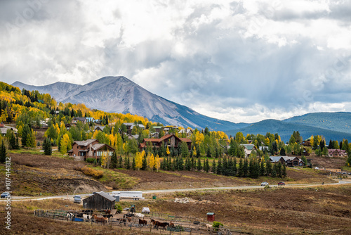 Mount Crested Butte, Colorado village town in autumn at Rocky mountains by apartment buildings, condos houses cityscape and farmland photo