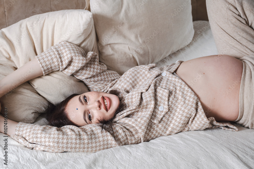 Beautiful pregnant woman lying on bed, conveying comfort and tranquility. Beautiful pregnant woman lying on bed, conveying comfort and tranquility.