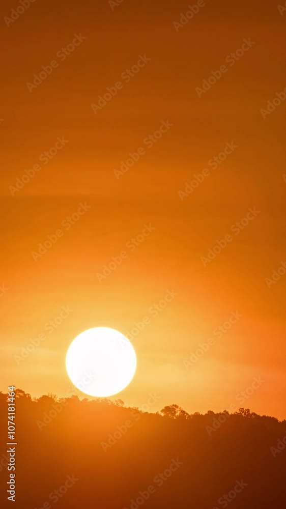 Timelapse of dramatic sunrise with orange sky in a cloudy day.