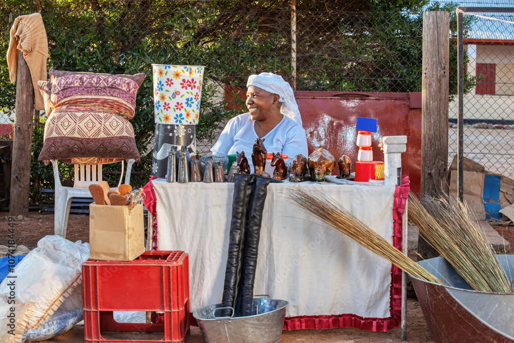 Fototapeta premium african street vendor selling cow bell and buckets, art and craft products, small entrepreneur business