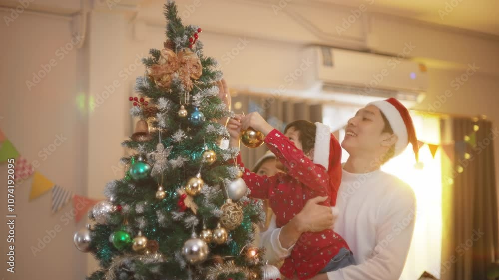 Happy family preparing New Year winter holidays celebration. Smiling young asian father and son enjoy decorating ornament on christmas tree create festive mood party atmosphere at home. slow motion. Happy family preparing New Year winter holidays celebration. Smiling young asian father and son enjoy decorating ornament on christmas tree create festive mood party atmosphere at home. slow motion.