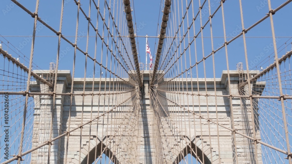 Fototapeta premium Brooklyn Bridge to Manhattan downtown, cables and blue sky. New York City iconic symbol, USA travel destination. Architecture of United States of America, tourist landmark. Famous cable-stayed bridge.