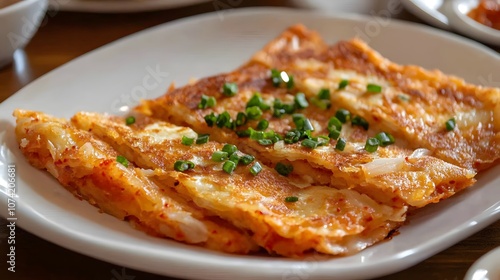 A serving of kimchi pancakes (kimchijeon), savory pancakes made with kimchi and flour, pan-fried until crispy.