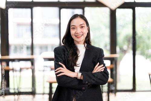 Beautiful young businesswoman looking at camera with smile while standing in office. Free Download Beautiful young businesswoman looking at camera with smile while standing in office. - GFXLoad