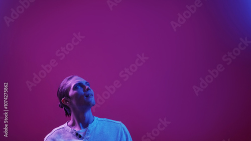 Idea inspiration. Creative search. Young handsome fascinated man enthusiastically looking up isolated on purple color empty space background.