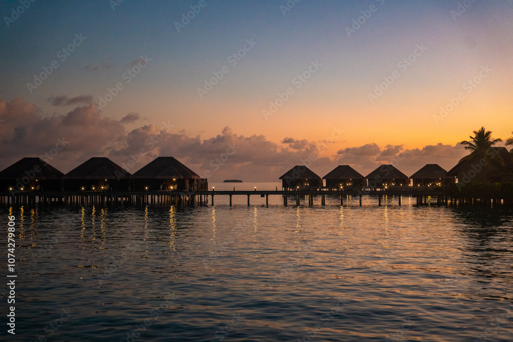 Obraz premium Sunset views from overwater pool villa in Maldives