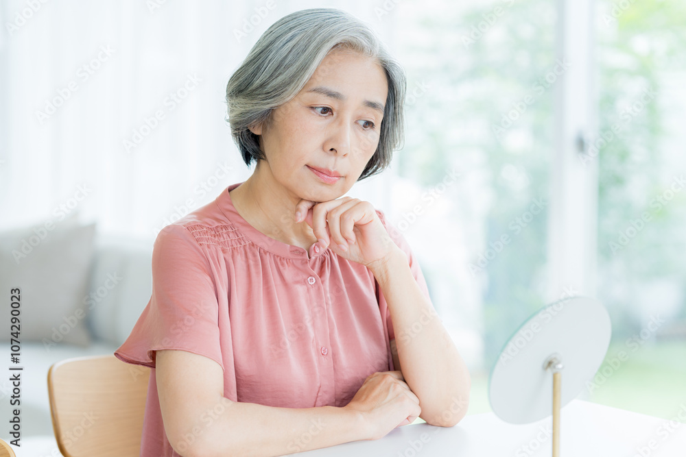悩むシニア女性 悩むシニア女性