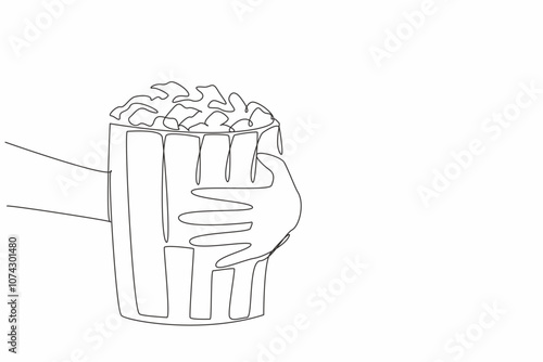 National Popcorn Day. One single line drawing of hand grabbing stripped pop corn paper bucket contain sweet popcorn. Delicious snack to accompany watching movie. Continuous line draw vector graphic