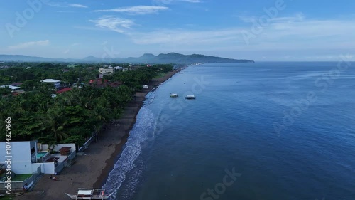 Wallpaper Mural Aerial shot gliding along the coast of the Philippines, showcasing a beach town near Taal Volcano, with stunning ocean views, sandy shores, and vibrant local life along the beachfront. Torontodigital.ca