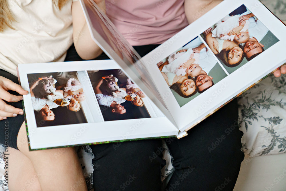 hands flip through the pages of a photo book with family photos.