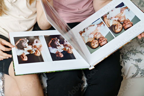 Obraz na płótnie hands flip through the pages of a photo book with family photos. w salonie