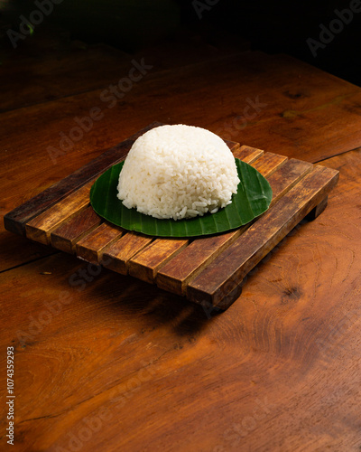 Only white rice served on banana leaf on wooden table