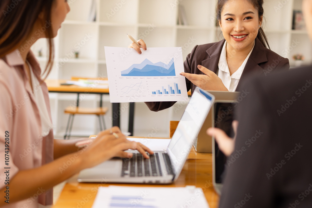 Fototapeta premium Asian businesswoman teamwork working on laptop with finances analysis report at desk in office, business financing, accounting banking, Team of creative and business planning,