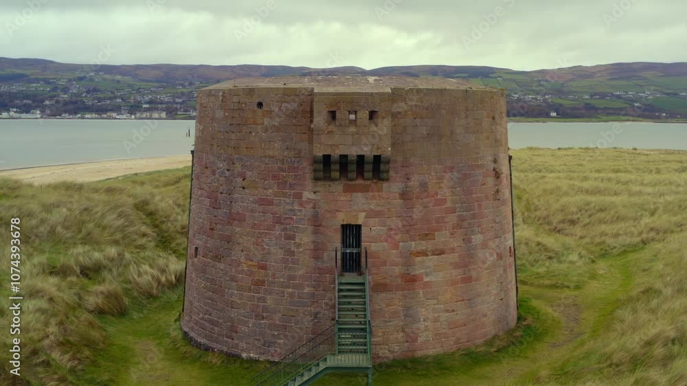 Smooth aerial pullback showcasing the Martello Tower at Magilligan Point, highlighting the entrance of the tower Smooth aerial pullback showcasing the Martello Tower at Magilligan Point, highlighting the entrance of the tower