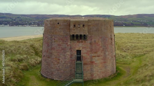 Smooth aerial pullback showcasing the Martello Tower at Magilligan Point, highlighting the entrance of the tower photo