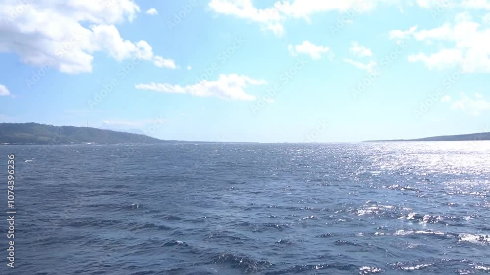 Open ocean with clear skies and white clouds on a quiet morning Open ocean with clear skies and white clouds on a quiet morning