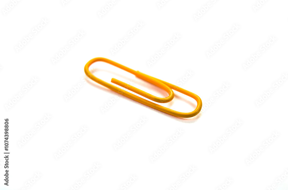 Orange paper clip isolated on white background. close up Orange paper clip isolated on white background. close up